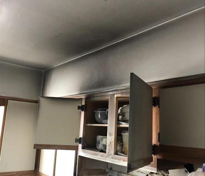 Kitchen cabinets and walls covered in soot