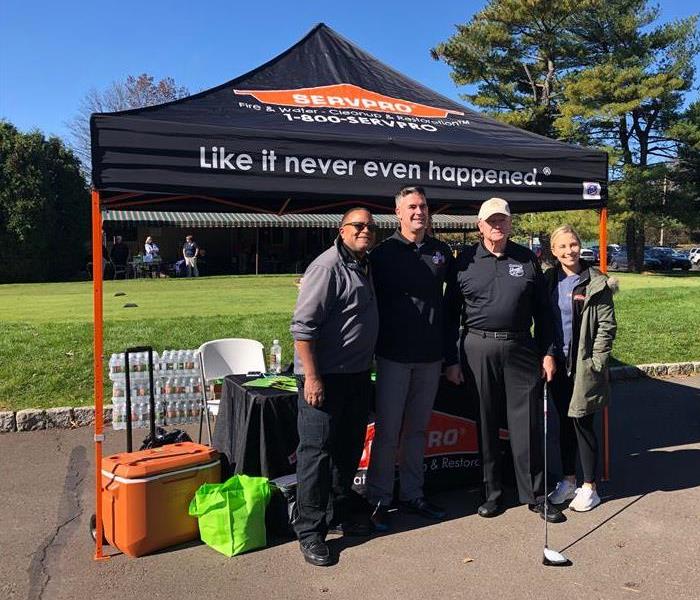 4 golfers in front of SERVPRO tent